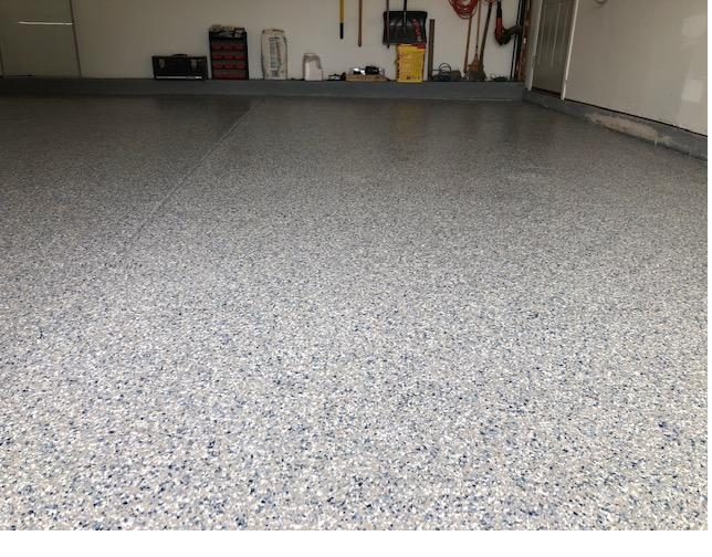 Full broadcast flake epoxy garage floor with speckled gray finish