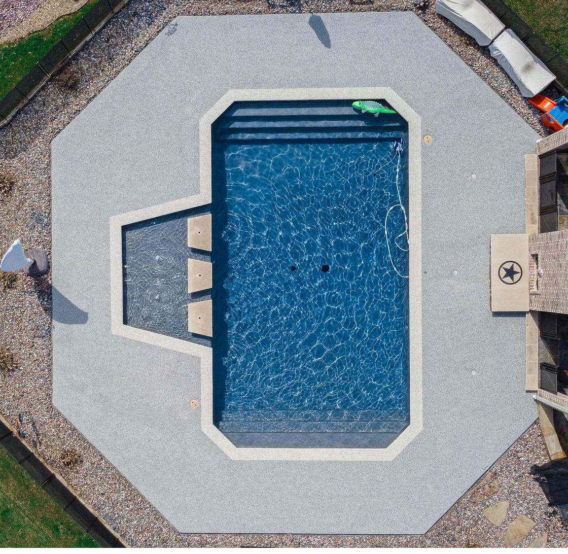 Cool touch textured pool deck coating around a backyard pool