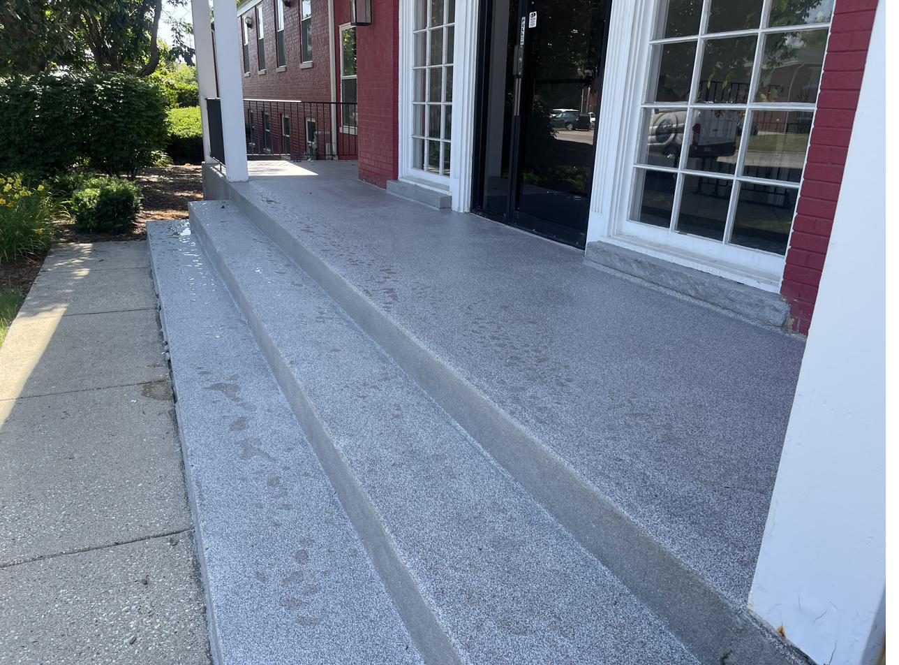 Coated exterior steps and walkway leading to a front door